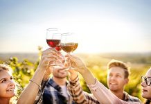 Happy people enjoying harvest time together at farmhouse winery countryside